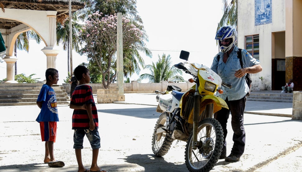 Local Timorese kids check out AUSMAT Paramedic, Peter Jones, motorbike as he finishes his final shift following riders through the hot and rough terrain of Tour de Timor 2016. Baucau, Timor-Leste.