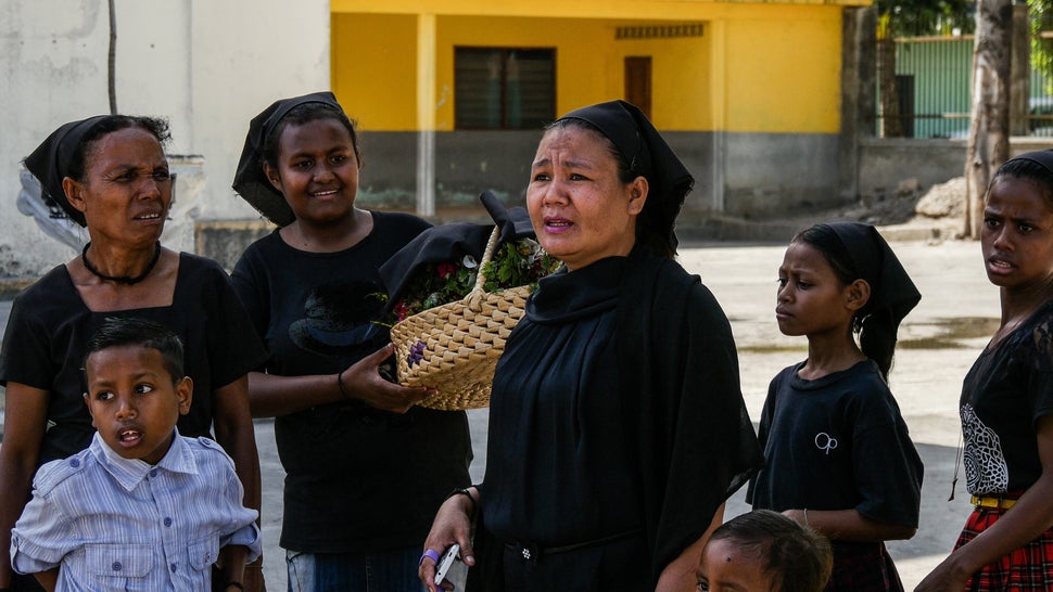 These women gather with their daughters and sons outside of the church at the finish line of Tour de Timor 2016. They wait and watch riders finish before making their way to service. Baucau, Timor-Leste.