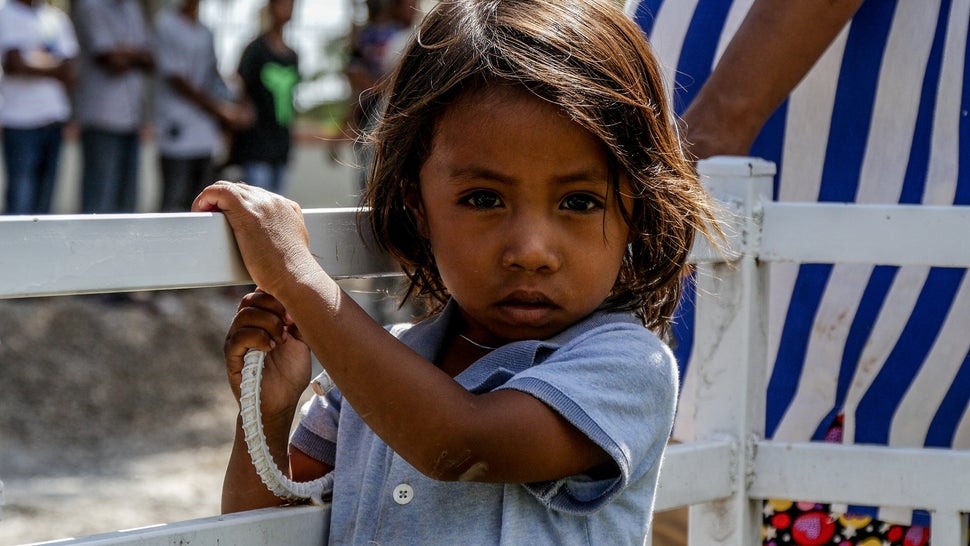 This little man waits patiently at the finish line of Tour de Timor 2016. The race brings a new town to life each day it passes through the 5 stages. Baucau, Timor-Leste.