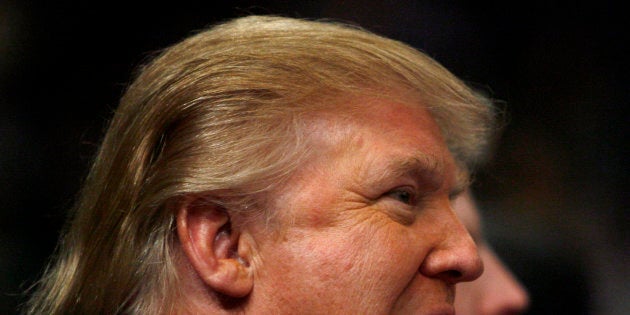 Donald Trump eats a french fry as the New York Knicks play Los Angeles Lakers in the first quarter of their NBA basketball game at Madison Square Garden in New York, January 30, 2007. REUTERS/Ray Stubblebine (UNITED STATES)