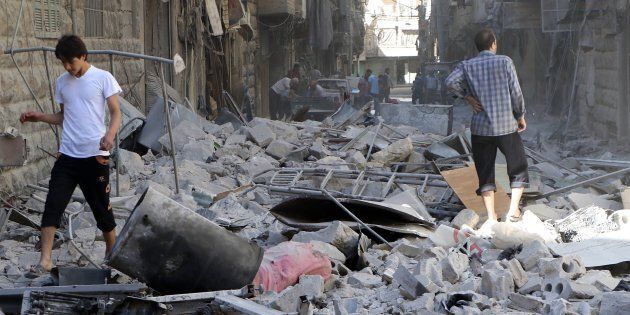 ALEPPO, SYRIA - SEPTEMBER 24: People inspect the debris of buildings after Syrian and Russian army carried out an airstrike on a residential area at Bustan Al-Qasr neighborhood of Aleppo, Syria on September 24, 2016. It is reported that 56 people were killed 220 people wounded after the attack. (Photo by Ibrahim Ebu Leys/Anadolu Agency/Getty Images)