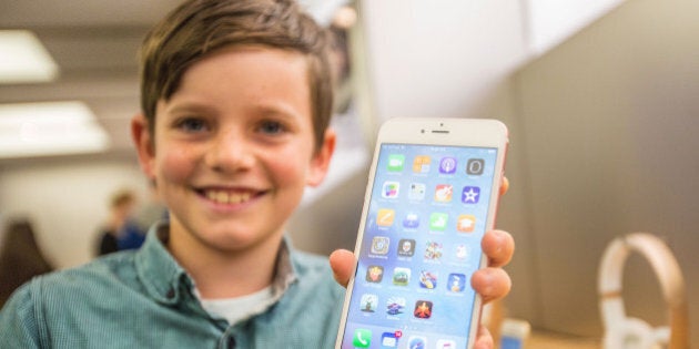 SYDNEY, AUSTRALIA - SEPTEMBER 25: Levi aged 10, shows of the new iPhone 6s Plus in rose gold as crowds wait in anticipation for the release of the iPhone 6s and 6s Plus at Apple Store on September 25, 2015 in Sydney, Australia. Some eager iPhone fans arrived to queue at 4am on Thursday morning to be the first to purchase Apple's new products, iPhone 6 and iPhone 6 Plus, with iOS 8 featuring 4.7-inch and 5.5-inch displays. (Photo by Cole Bennetts/Getty Images)