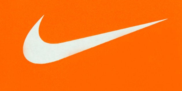 TORONTO, ONTARIO, CANADA - 2015/03/29: White Nike Logo on Orange Background;Nike, Inc. is an American multinational corporation that is engaged in the design, development, manufacturing and worldwide marketing and sales of footwear, apparel, equipment, accessories and services. (Photo by Roberto Machado Noa/LightRocket via Getty Images)