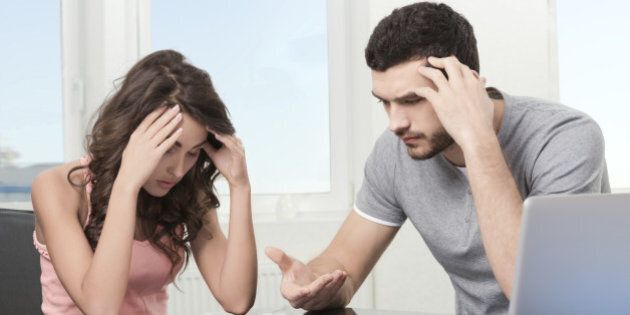 Couple, Man angry and upset after looking at credit card statement.