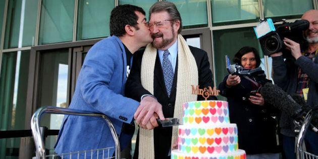 Labor Senator Sam Dastyari gives a kiss to Senator Derryn Hinch over a marriage equality themed cake.