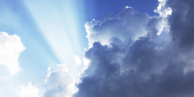 Dramatic blue sky with sun rays bursting through the clouds