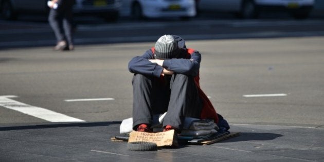 A homeless man sits on a street in the Central Business District of Sydney as the Australian government prepares to release its 2015/16 budget on May 12, 2015. Australian Treasurer Joe Hockey insisted he will deliver a 'responsible and fair' budget as the government battles to juggle slumping revenue and a huge deficit while avoiding a voter backlash. AFP PHOTO/Peter PARKS (Photo credit should read PETER PARKS/AFP/Getty Images)