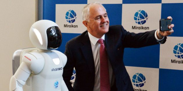Australian Prime Minister Malcolm Turnbull (R) takes a selfie with Japanese auto giant Honda Motor's humanoid robot Asimo (L) at the National Museum of Emerging Science and Innovation in Tokyo on December 18, 2015. Turnbull is on a one-day visit to Tokyo and will have talks with Japanese counterpart Shinzo Abe. AFP PHOTO / POOL / Yoshikazu TSUNO / AFP / POOL / YOSHIKAZU TSUNO (Photo credit should read YOSHIKAZU TSUNO/AFP/Getty Images)
