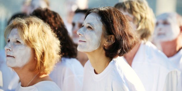 Demonstrators from the environmental group Greenpeace paint their faces white to highlight coral bleaching in Sydney, Friday, April 22, 2016. The group are attempting to raise concerns of climate change when as many as 170 countries are expected to sign the Paris Agreement on climate change as the landmark deal takes a key step toward entering into force years ahead of schedule. (AP Photo/Rick Rycroft)