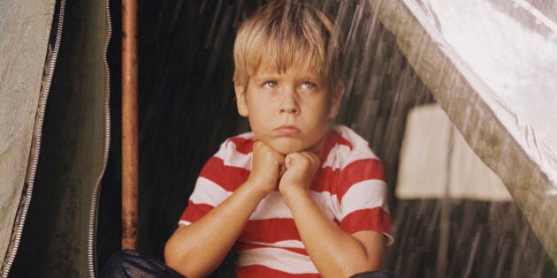 Sad Young Boy Camping in the Rain