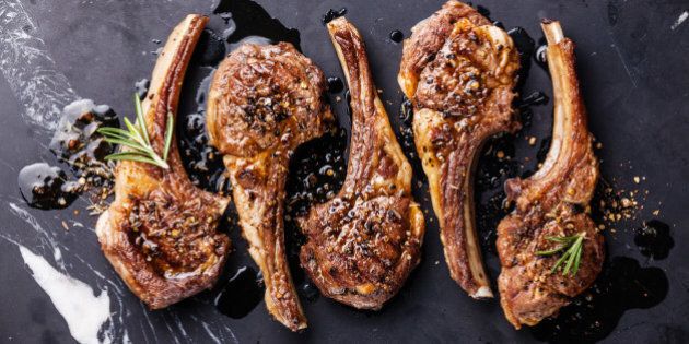 Roasted lamb ribs with spices on black marble background