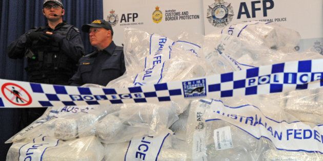 Australian Federal Police (AFP) guard 525 million USD worth of crystal methamphetamine ('ice') and heroin after smashing a Hong Kong-based international drugs syndicate in Sydney on July 31, 2012. It was the largest haul of ice (306 kilograms) in Australian history and the third-biggest heroin bust (252 kilograms) and was the culmination of an 11-month operation following a tip-off from the US Drug Enforcement Administration. AFP PHOTO / Torsten BLACKWOOD (Photo credit should read TORSTEN BLACKWOOD/AFP/GettyImages)