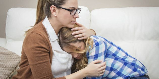 Mother embracing and soothes depressed teen daughter by problems