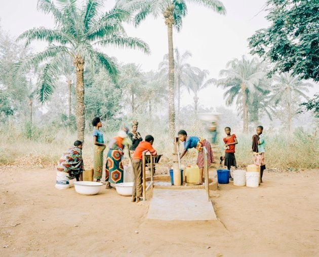 The water pump in Osukputu, Benue, Nigeria -- women and children gather at a hand pump which serves the community of 800 people with clean, safe water.