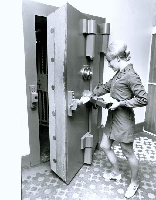 1960-1970: this lady wore the beehive beautifully as she posted for a photo at the State Bank, opening a safe.