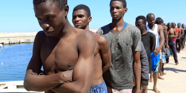 JULY 8, 2017: Illegal migrants from Africa, attempting to reach Europe, walk towards a detention center off the coastal town of Guarabouli.