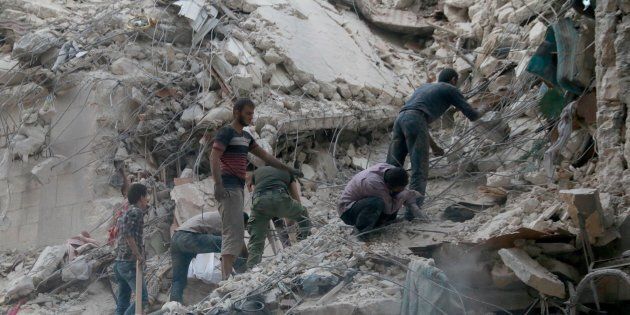 ALEPPO, SYRIA - SEPTEMBER 28: Search and rescue team members carry out search and rescue operation on the rubble of a building after the war crafts belonging to the Russian Army bombed in the al-Shear district of Aleppo, Syria on September 28, 2016. (Photo by Jawad al Rifai/Anadolu Agency/Getty Images)