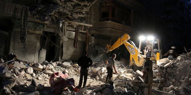 Civil Defense members search for survivors at a site hit by an airstrike in the rebel-held al-Shaar neighbourhood of Aleppo, Syria, September 27, 2016.