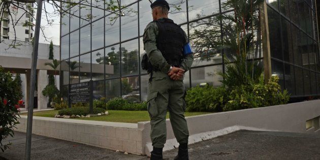 A policeman stands guard outside the Mossack-Fonseca law firm offices in Panama City during a raid on April 12, 2016. Police on Tuesday raided the headquarters of the Panamanian law firm whose leaked Panama Papers revealed how the world's wealthy and powerful used offshore companies to stash assets. / AFP / Ed Grimaldo (Photo credit should read ED GRIMALDO/AFP/Getty Images)