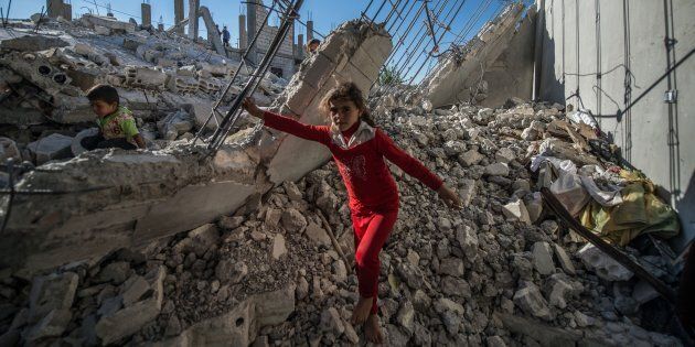 ALEPPO, SYRIA - OCTOBER 01: Children are seen on the rubble of a building in the Jarabulus district of Aleppo, Syria on October 1, 2016. Families, who returned to their homes back in Jarabulus after its cleansing from Daesh terrorist organization as part of the Operation 'Euphrates Shield', try to rebuild their houses before winter comes. The anti-Daesh operation called Euphrates Shield, which was launched on August 24, aims at improving security, supporting coalition forces, supporting Syrias territorial integrity and eliminating the terror threat along Turkeys border through Free Syrian Army (FSA) fighters backed by Turkish armor, artillery, and jets. (Photo by Halil Fidan/Anadolu Agency/Getty Images)