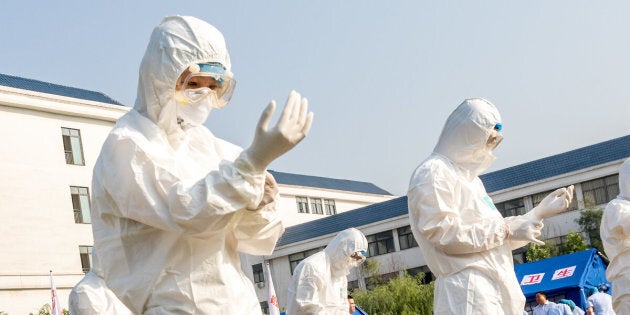 Health workers act in an exercise dealing with an outbreak of H7N9 avian flu on June 17 in Hebi, China.