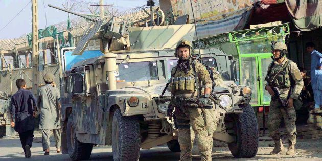 Afghan security forces keep watch in front of their armored vehicle in Kunduz city, Afghanistan on October 4, 2016.