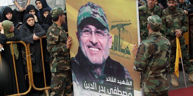 Hezbollah members carry a portrait of to commander Mustafa Badreddine during his funeral in Beirut on Friday. The Lebanese Shi'ite movement blamed hardline Sunni rebels for his death in Syria.