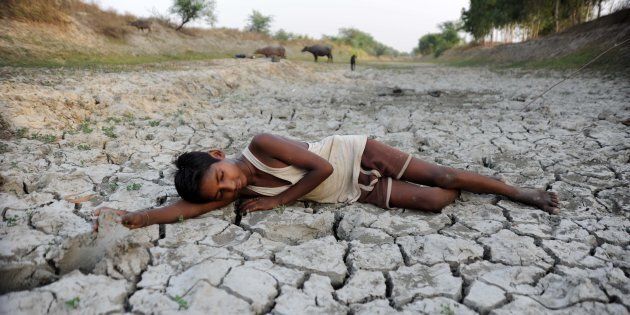 ALLAHABAD, UTTAR PRADESH, INDIA - 2016/05/14: A child lies down on a dry bed of parched mud that is the dried up River Varuna at Phoolpur. Much of India is reeling from a heat wave and severe drought conditions that have decimated crops, killed livestock and left at least 330 million Indians without enough water for their daily needs. (Photo by Prabhat Kumar Verma/Pacific Press/LightRocket via Getty Images)