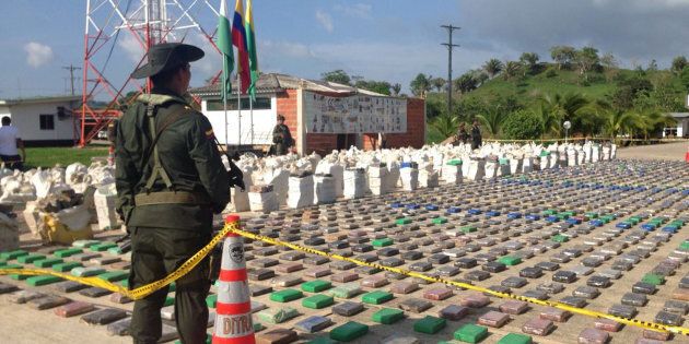 A Colombian national policeman stands guard in front of packages of cocaine, which were confiscated in Turbo province near the border with Panama, May 15, 2016. Colombian Police/Handout via REUTERS ATTENTION EDITORS - THIS PICTURE WAS PROVIDED BY A THIRD PARTY. EDITORIAL USE ONLY