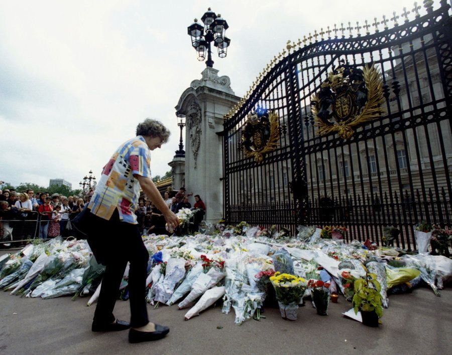 A woman adds another bouquet of flowers to the growing floral tribute outside Buckingham Palace August 31, 1997.