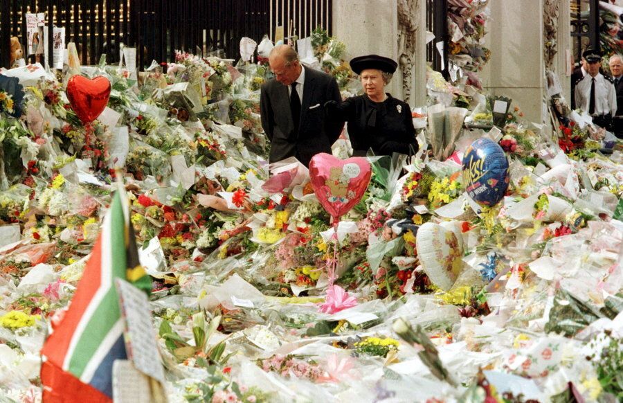 Queen Elizabeth and the Duke of Edinburgh look at floral tributes laid outside Buckingham Palace.