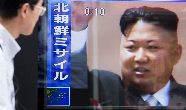 A pedestrian walks past a monitor showing an image of North Korean leader Kim Jong-Un in a news program reporting on North Korea's missile launch in Tokyo, Japan.