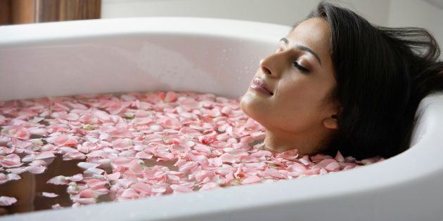 woman in tub with floating petals
