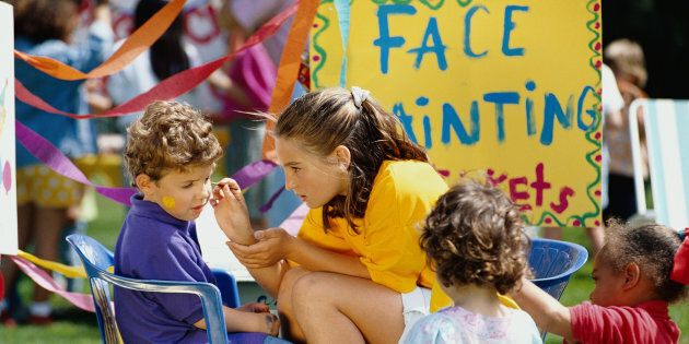 A group of children enjoy face painting.