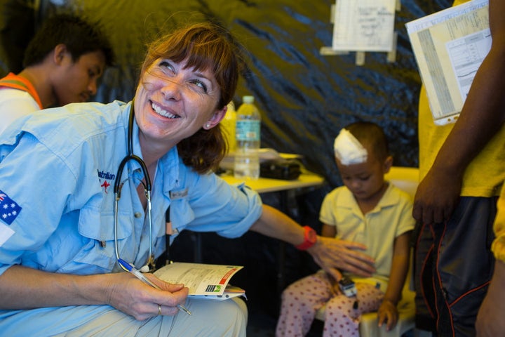 Paramedic Abigail Trewin with a young patient in a hospital built in Tacloban, the Philippines after a typhoon.