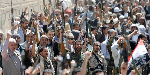 Armed people demonstrate outside the United Nations offices against Saudi-led air strikes on funeral hall in Sanaa, the capital of Yemen, October 9, 2016