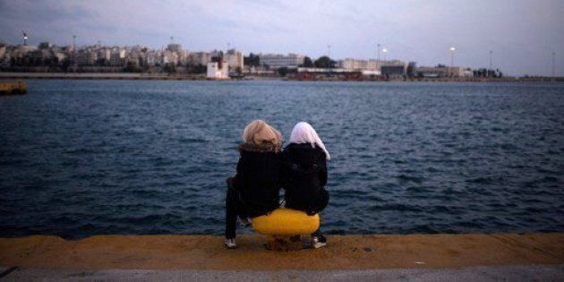 Two women from Syria sit facing the sea in Athens in March 2016.