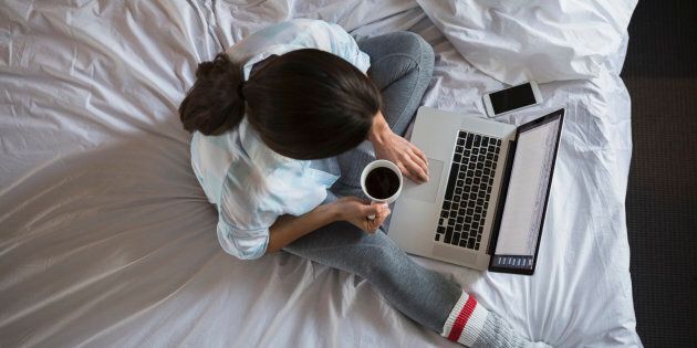 Overhead view of woman with coffee at laptop