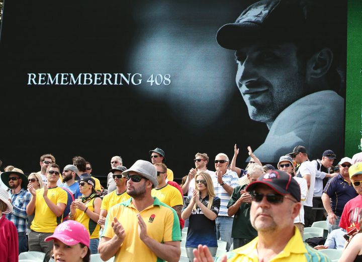 Spectators salute Hughes at the first Test match after his death in 2014.
