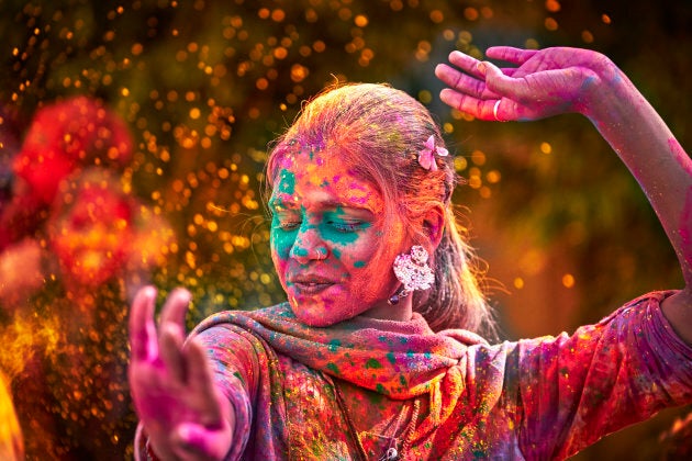 A young Indian woman dancing during Holi Festival.