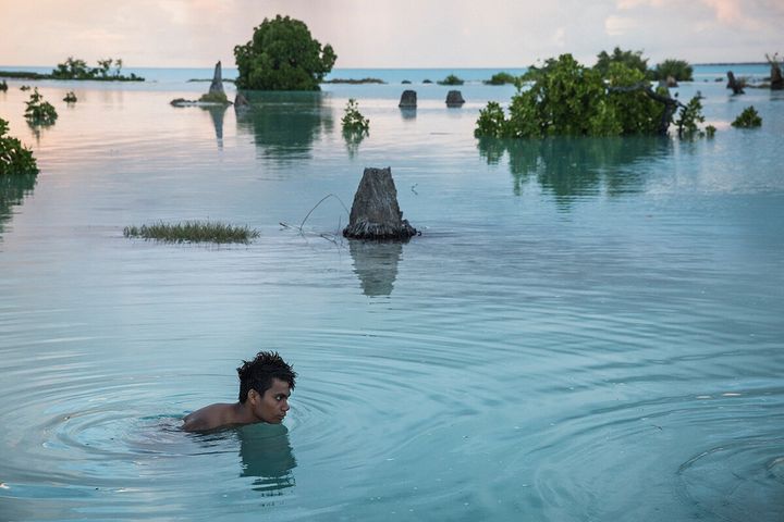 Peia Kararaua, 16, swims in the flooded area of Aberao village. Kiribati is one of the countries most affected by sea level rise. During high tides many villages become inundated making large parts of them uninhabitable.