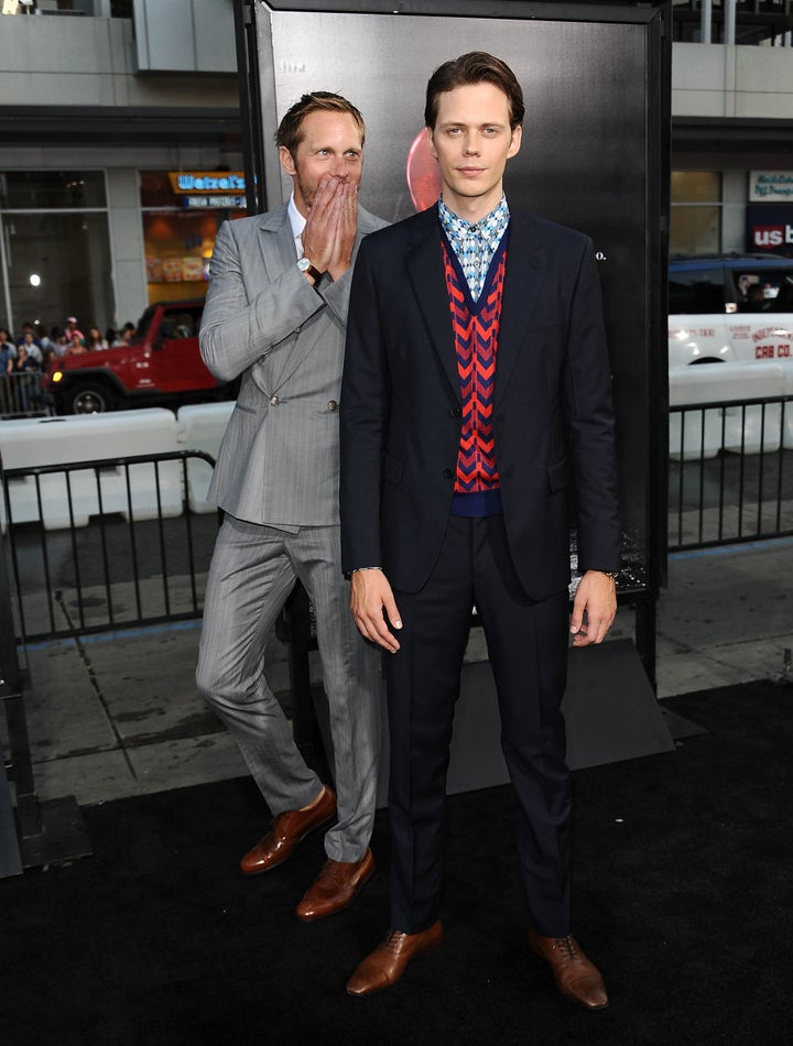 Taking things very seriously, big brother Alexander walks the red carpet with brother Bill.