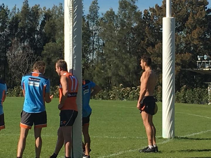 Stevie J holds up a goal post. Shane Mumford is just about as big as one.