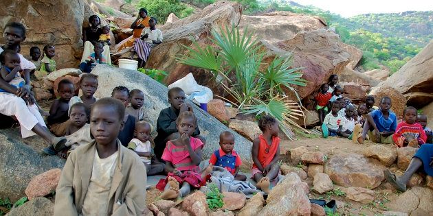Women and children climb rocky hillsides near Kauda in Sudan's Nuba Mountains to seek cover from government air strikes. Over the past month, Sudan has significantly increased aerial attacks in the rebel-controlled area.