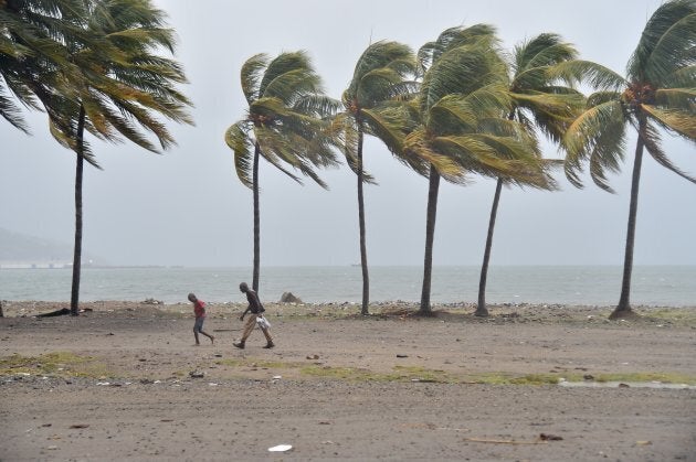 Haitian people walk through the wind and rain on a beach, in Cap-Haitien as Hurricane Irma approaches.