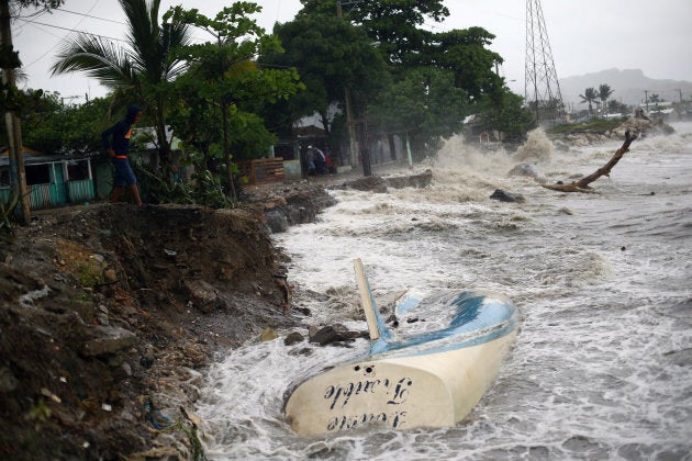 Waves crash against the shore and a stranded boat as Hurricane Irma moves off from the northern coast of the Dominican Republic.