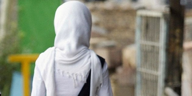 An Iranian woman walks at a street in Tehran, 13 July 2004. A fresh crackdown by Iranian police targeting insufficiently veiled women has prompted a serious debate within the Islamic republic's now-dominant conservatives over how to tackle what they see as an erosion of Islamic values. Police have been carrying out a series of operations, rounding up large numbers of young women sporting flimsy headscarves, three-quarter length trousers and shape-revealing coats. Witnesses said the detainees, picked up in parks, fast food restaurants or from sidewalks, were subjected to lessons on morality before being freed. AFP PHOTO/Behrouz MEHRI (Photo credit should read BEHROUZ MEHRI/AFP/Getty Images)