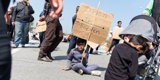 A boy holds a sign on April 4, 2016 on the third day of protest along the highway outside Polykastro, in Central Macedonia, Greece.