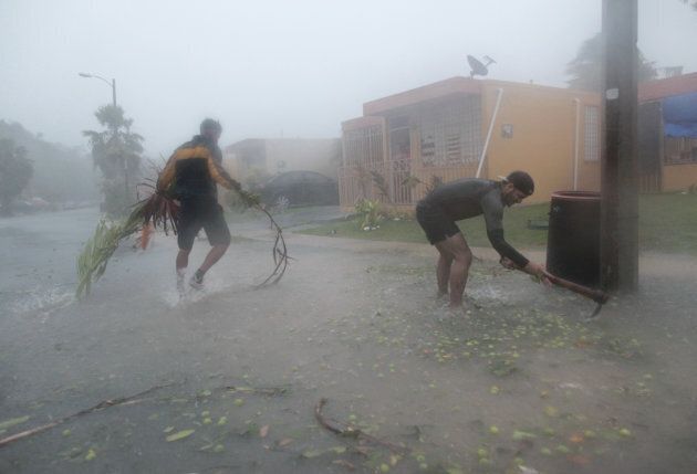 People pick up debris as Hurricane Irma howled past Puerto Rico after thrashing several smaller Caribbean islands, in Fajardo, Puerto Rico September 6, 2017.