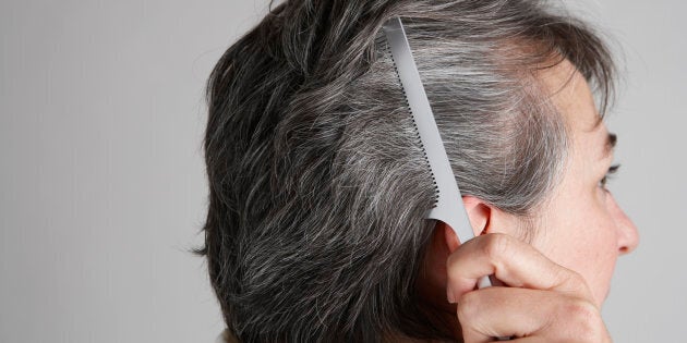 Mature woman combing hair, close-up